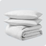 A folded stack of a printed flannel duvet cover with two pillows on top.